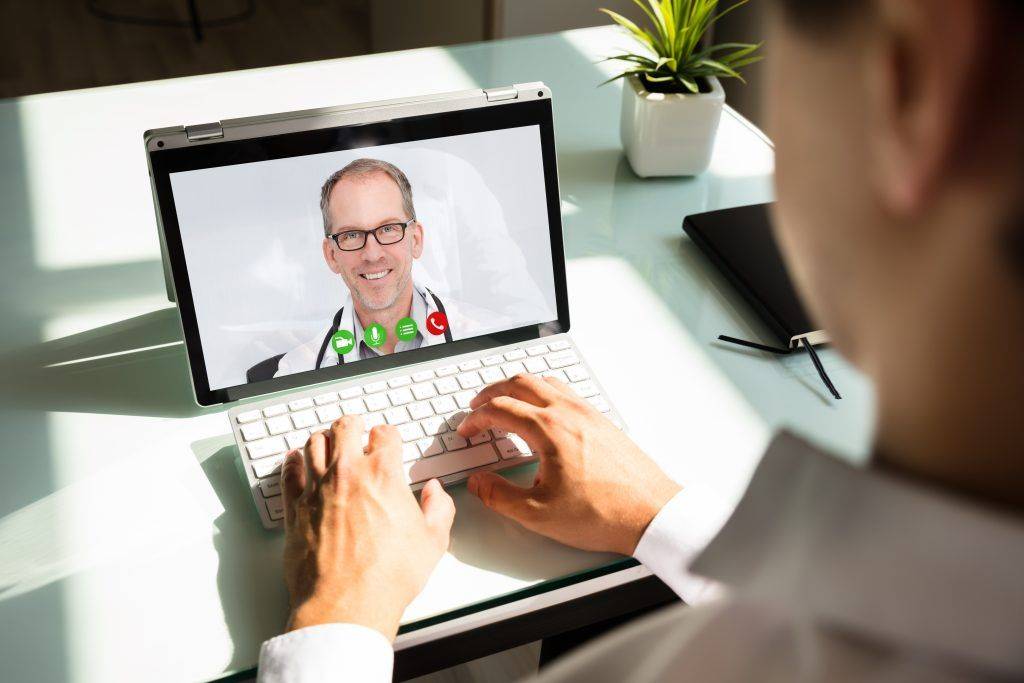 man using telemedicine service on tablet at home