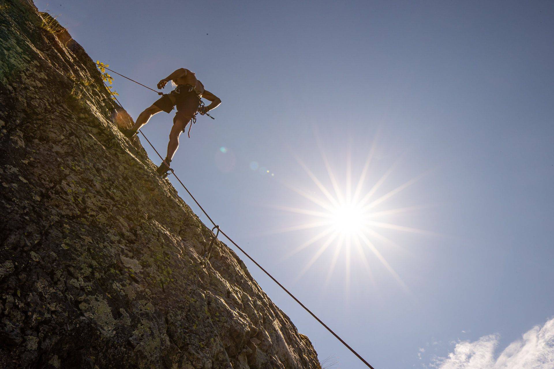 man rock climbing in the summer