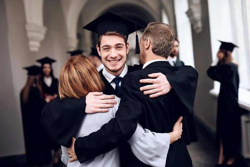 son studying abroad hugs parents at college graduation