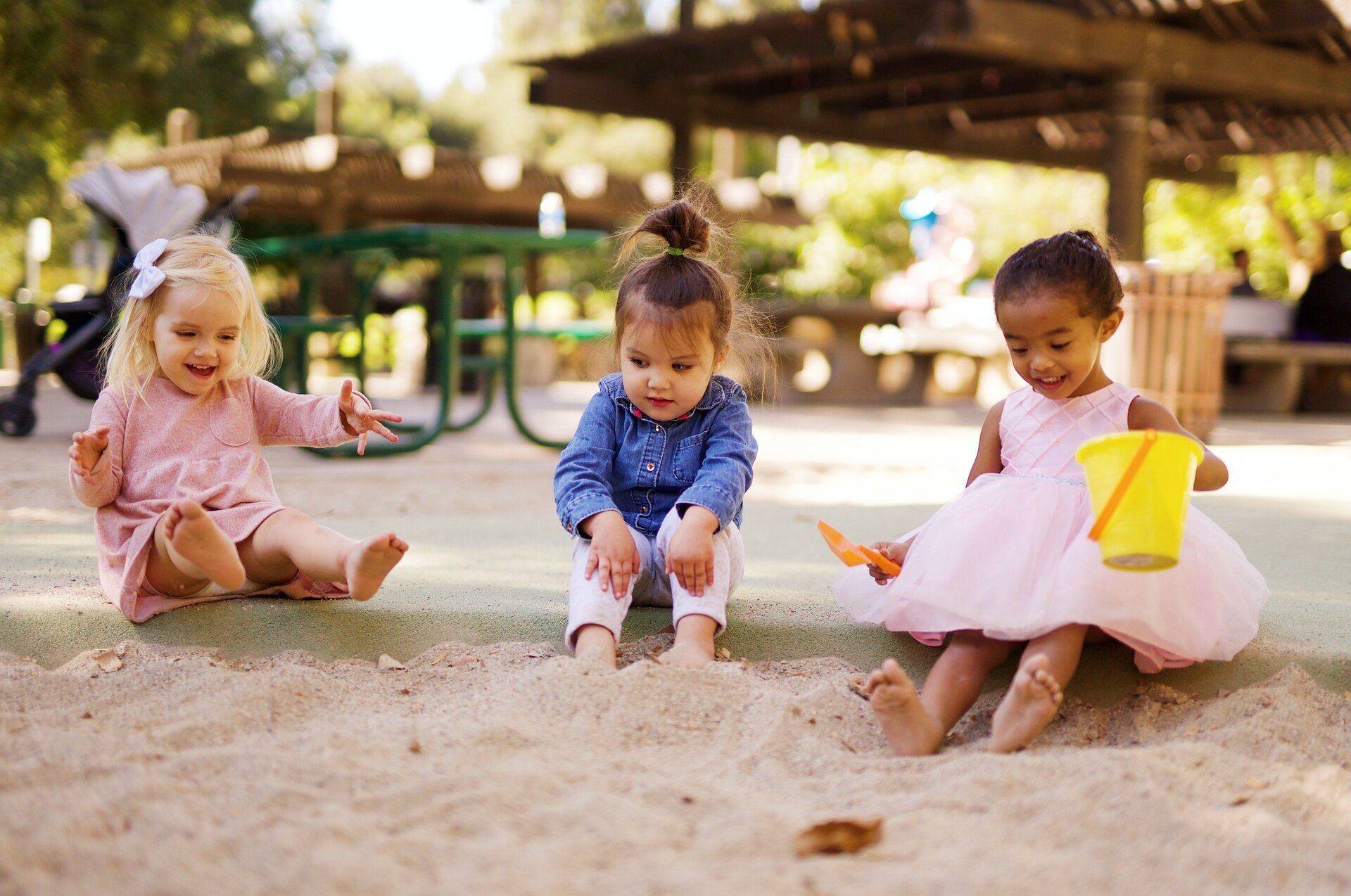 three girls playing in sandpit