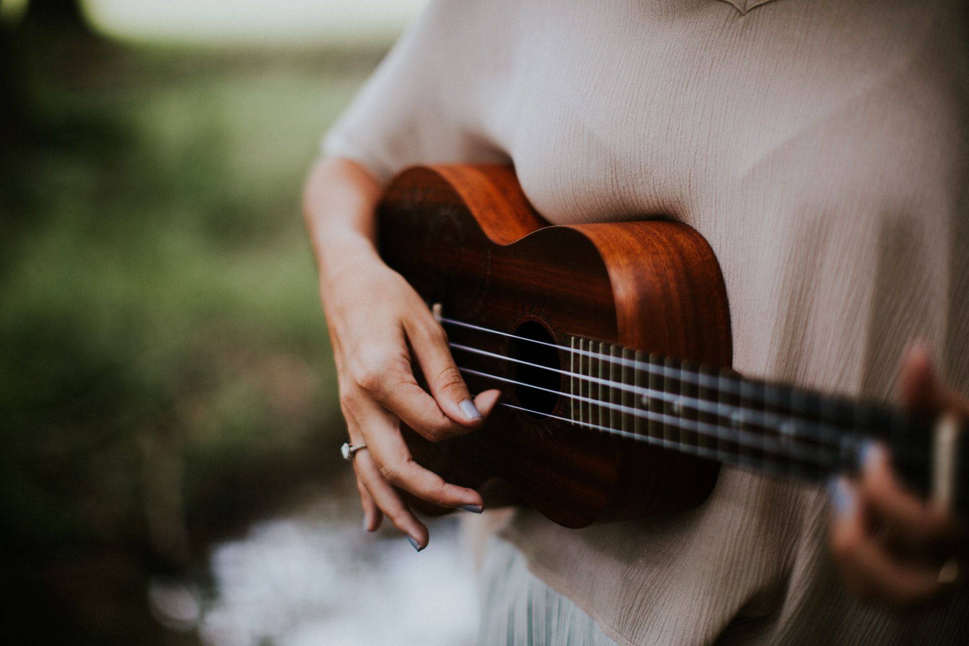 woman playing ukulele outdoors