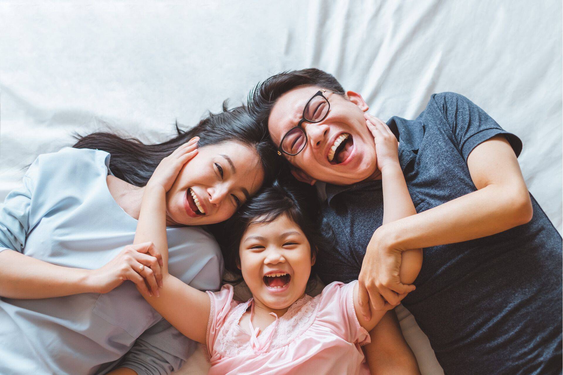 happy family with daughter in the middle smiling
