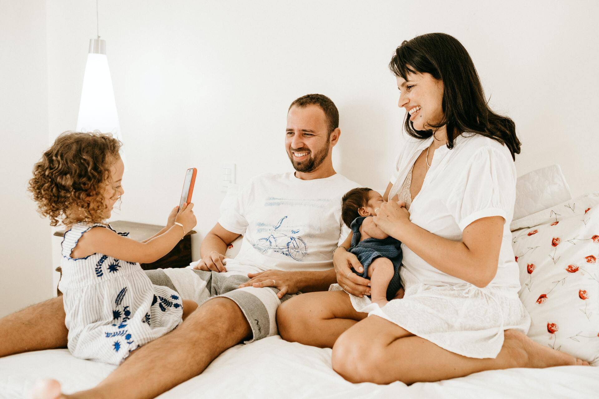 family with young children sitting on a bed