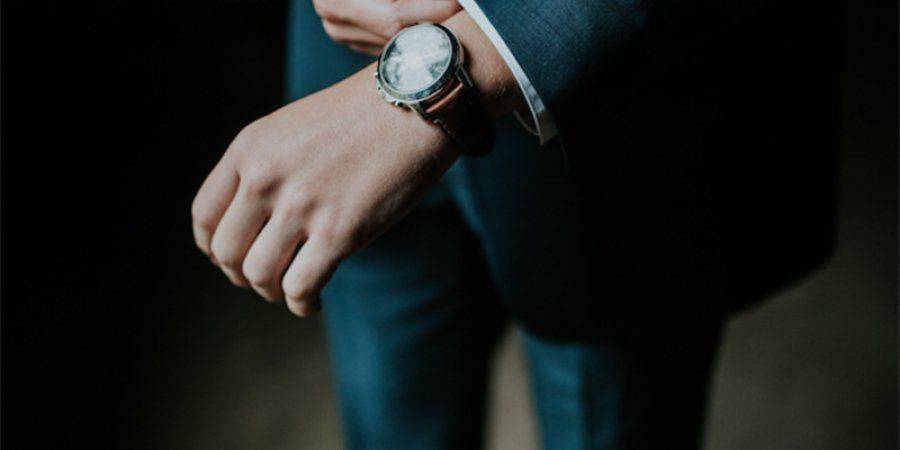 man with watch in a suit getting ready for work