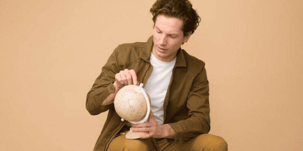 Expat man with a globe in his hands