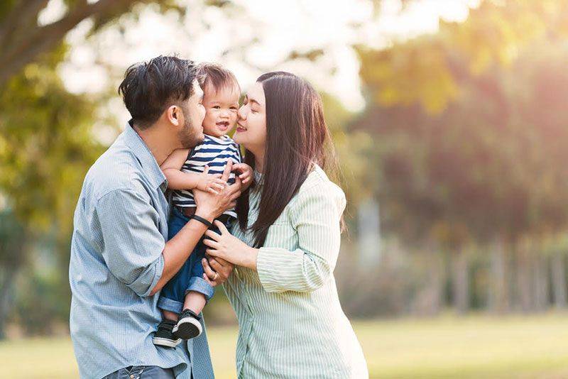 Asian couple holding their baby