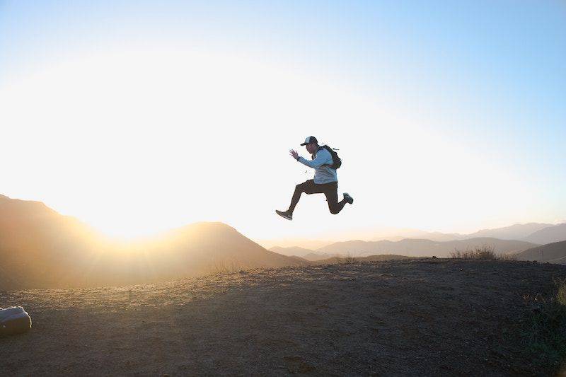 man jumping up in the air with sunset